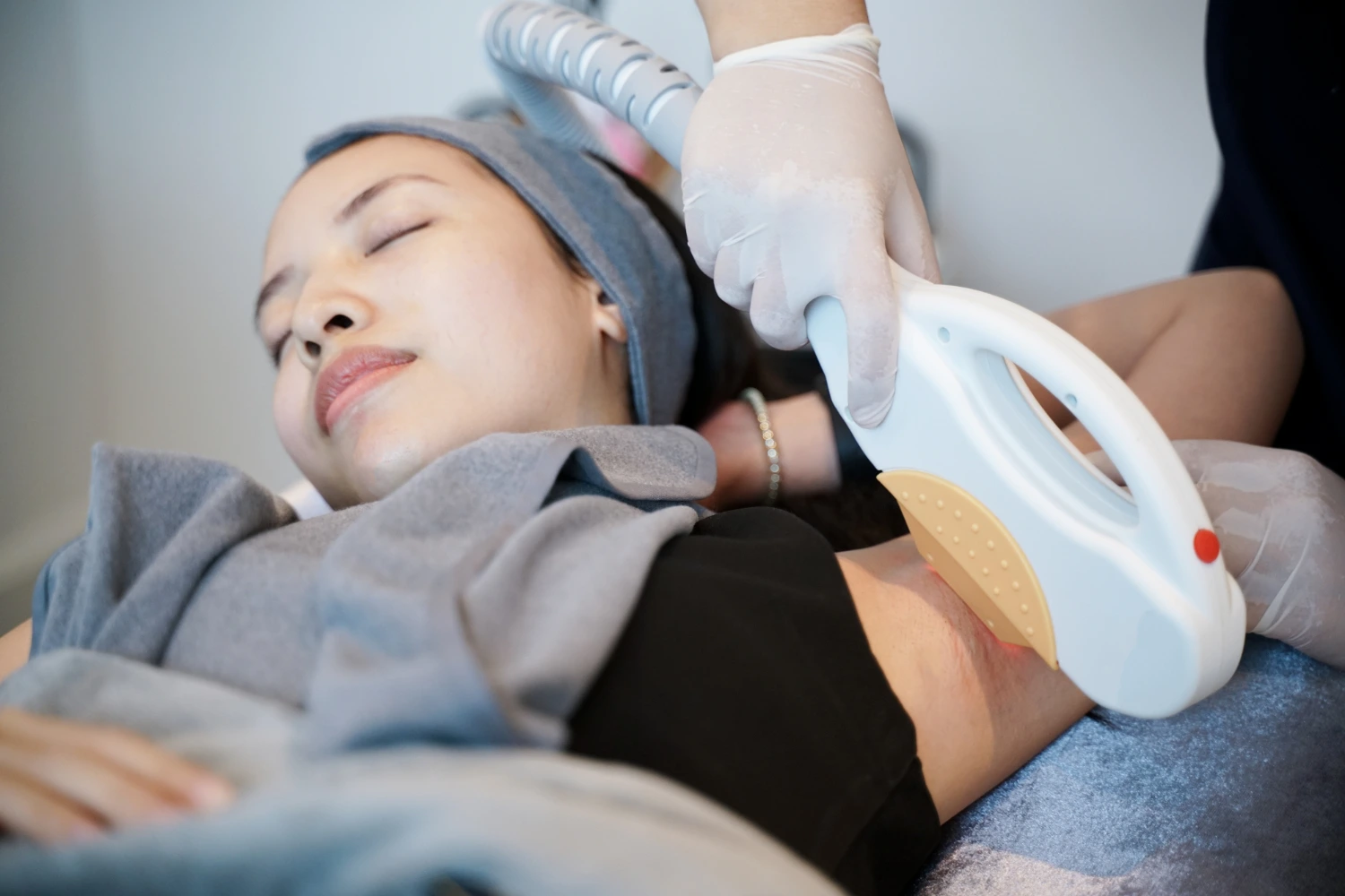 Lady undergoing Intense Pulsed Light (IPL) treatment for her underarms at clinic.