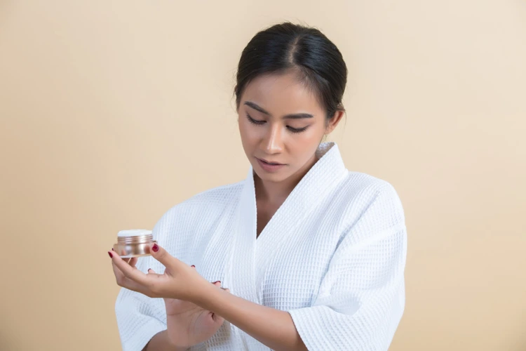 Lady applying acne medication cream on her lower wrist.